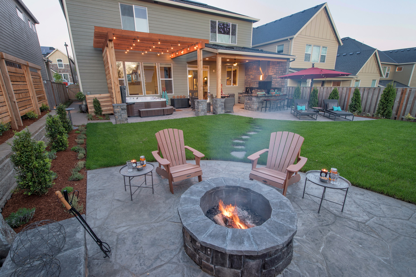 Patio in the back of a home topped with a built-in firepit.
