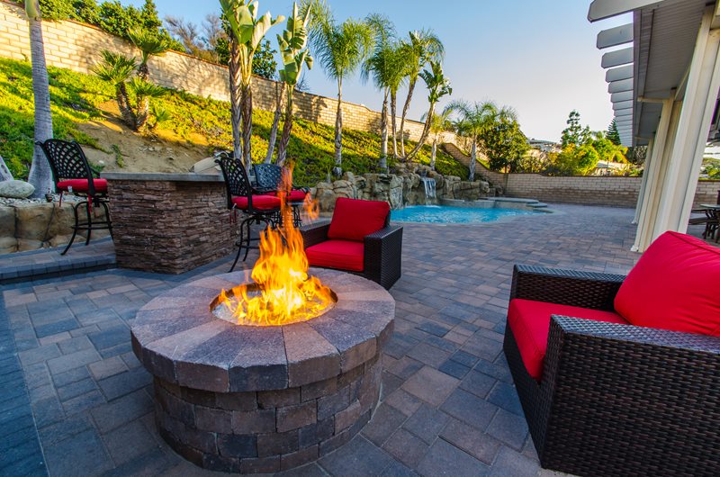 Circular firepit with a pool in the background.